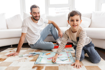 parent with his child playing monopoly