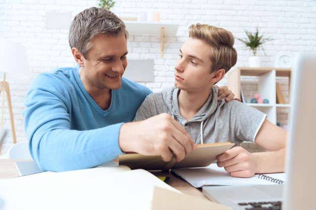 Father helps his son who is doing homework