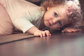 A baby peeping under a table