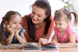 mother reading from a book to her daughters