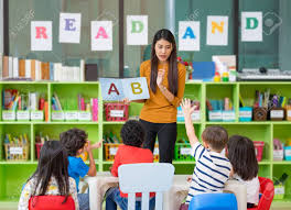 teacher teaching English alphabets to kids