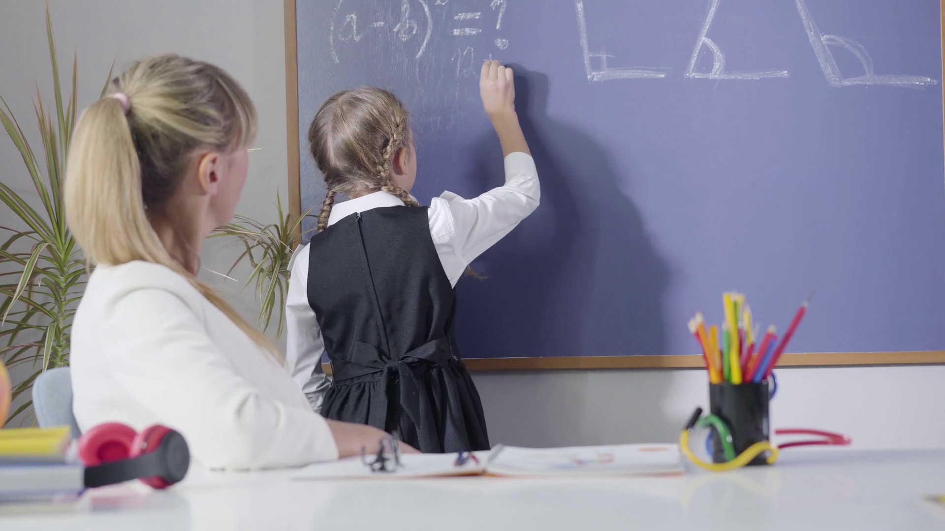 A child solving word problems in-front of teacher with the help of diagrams
