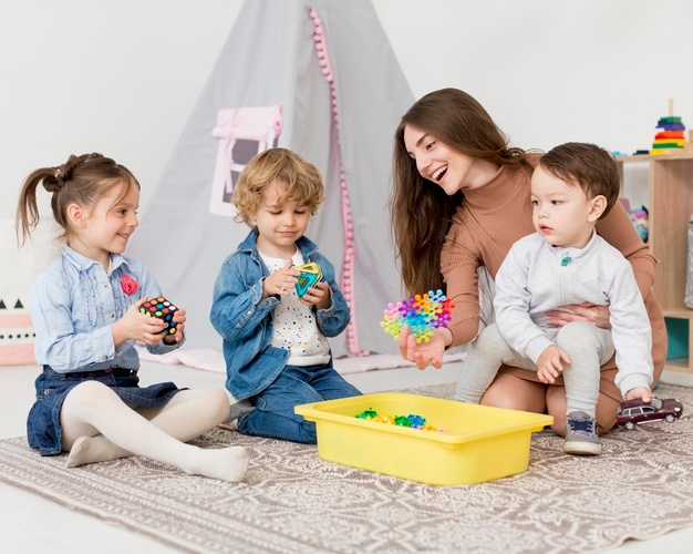 Woman playing with children at home with toys